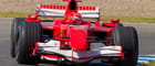 Coche de F1 rojo en un circuito.